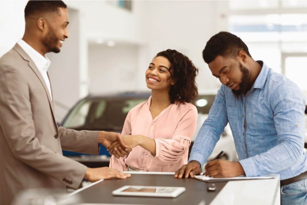 Couple Finalizing Car Deal at a Kia Dealership